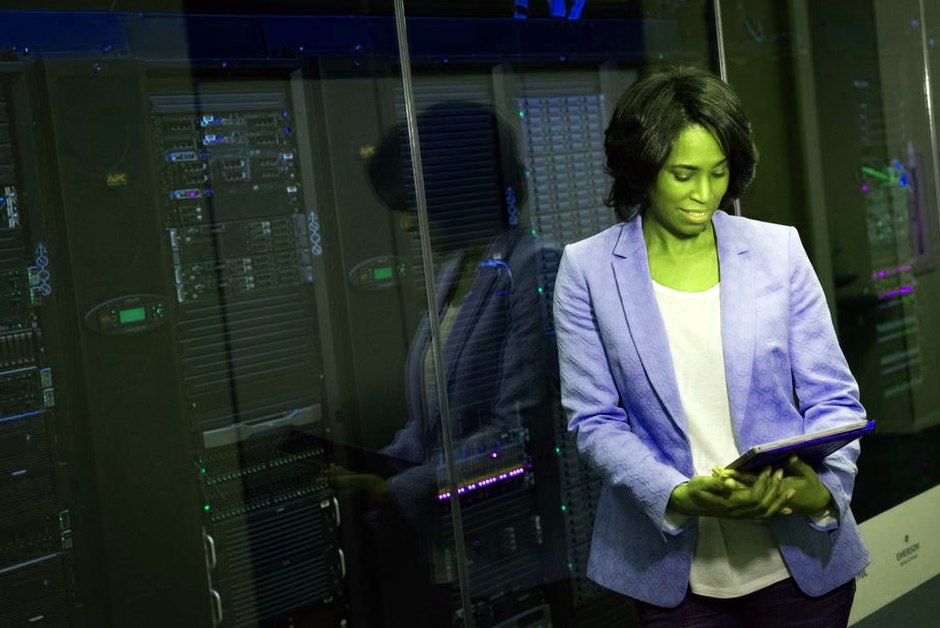 Professionnelle IT inspectant des serveurs dans un datacenter.
